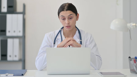 Female Doctor Talking on Video Chat on Laptopの写真素材