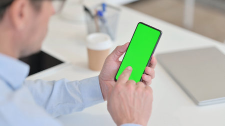 Middle Aged Man using Smartphone with Chroma Screenの写真素材