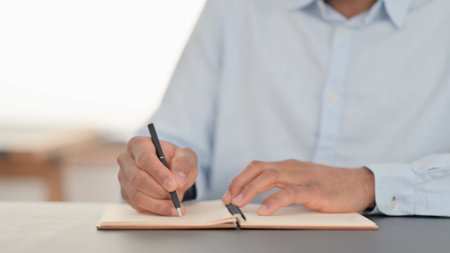 Hands of African Man Writing on Notebook, Close upの写真素材