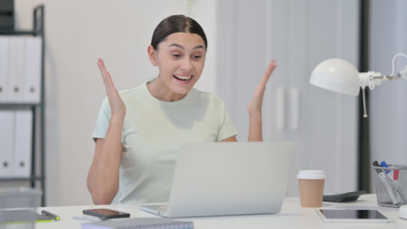 Young Latin Woman with Laptop Celebrating Successの写真素材