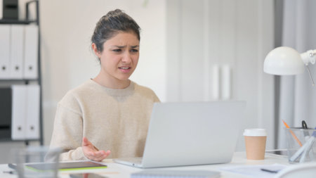 Tense Young Indian Woman Frustrated by Loss at Workの写真素材