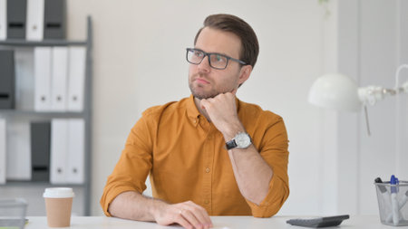 Brainstorming Young Man Thinking in Officeの写真素材