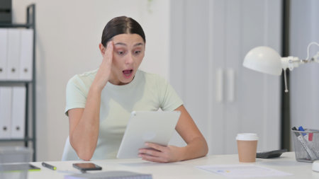 Young Latin Woman Reacting to Loss on tabletの写真素材