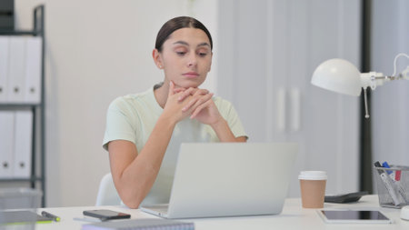 Young Latin Woman Thinking at Workの写真素材