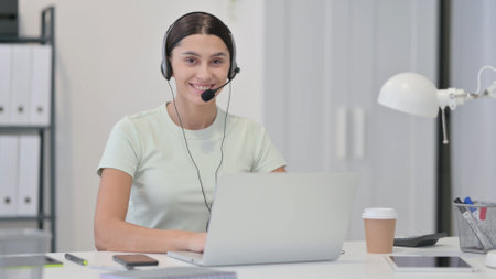 Call Center Woman with Laptop Smiling at Cameraの写真素材