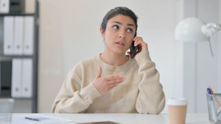 Phone Negotiation at Work by Indian Womanの写真素材