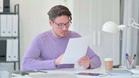 Middle Aged Man Reading Documentsの写真素材