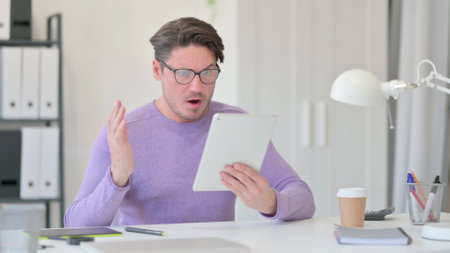 Middle Aged Man having Loss on Tabletの写真素材