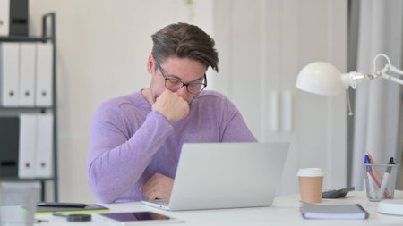 Middle Aged Man with Laptop taking Nap in Officeの写真素材