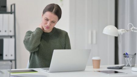 Young Woman with Laptop having Neck Painの写真素材