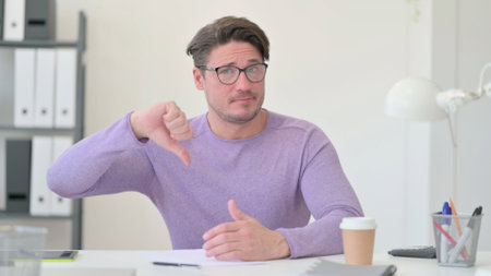 Middle Aged Man Showing Thumbs Down Signの写真素材