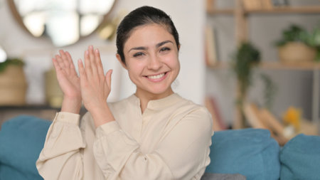 Portrait of Positive Indian Woman Clapping at Homeの写真素材