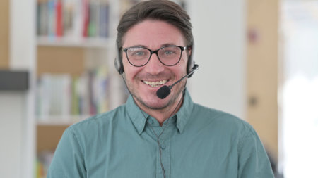 Middle Aged Man with Headset Smiling at the Cameraの写真素材