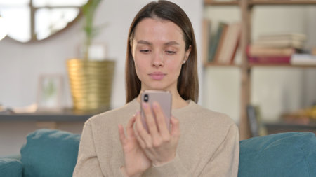 Portrait of Young Woman using Smartphone at Homeの写真素材