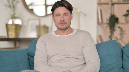 Serious Middle Aged Man Looking at the Camera at Homeの写真素材