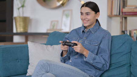 Attractive Latin Woman Playing Video Game on Sofa