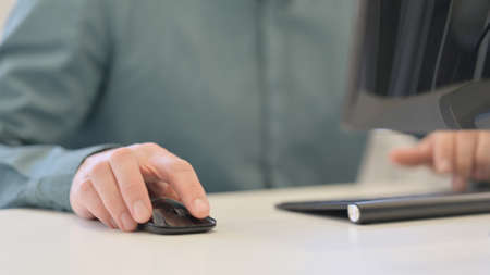 Man Using Mouse and Typing on Keyboard