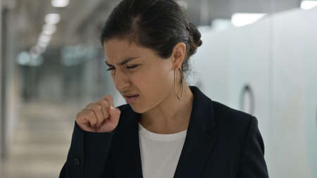 Portrait of Sick Young Indian Businesswoman Coughingの写真素材