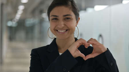Portrait of Young Indian Businesswoman showing Heart Sign with Handの写真素材