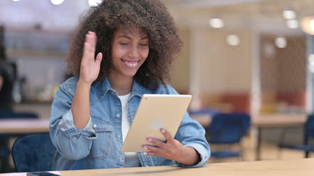 African Woman Waving Hand for Video Chat on Tablet