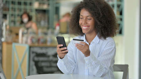 Successful Online Payment on Smartphone by Young African Woman in Cafe