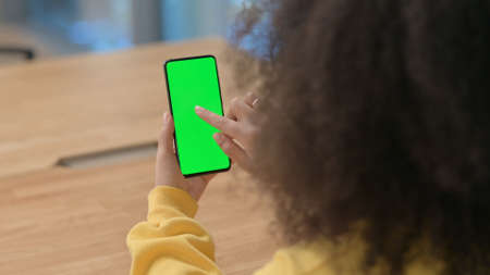 African Woman using Smartphone with Green Chroma Key Screenの写真素材