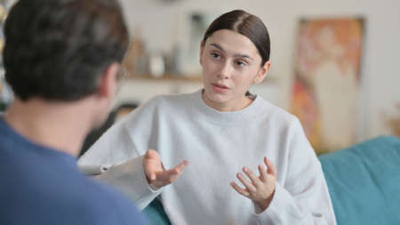 Latin Woman Talking to Husband at Homeの写真素材