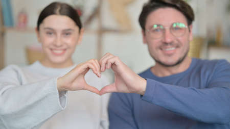Mixed Race Couple Making Heart Shape Togetherの写真素材
