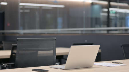 Empty Office with Open Laptop on Deskの写真素材