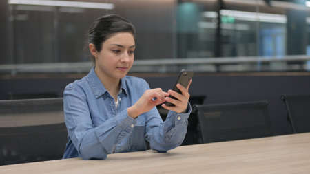 Indian Woman using Smartphone at Workの写真素材