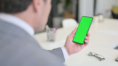 Businessman Holding Smartphone with Green Chroma Key Screenの写真素材