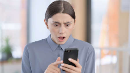 Portrait of Latin Woman having Loss on Smartphoneの写真素材
