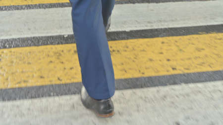 Close up Shot of Feet of Young Businessman Walking on Pavement, Back View