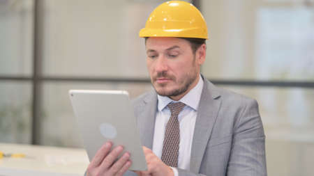 Portrait of Attractive Middle Aged Engineer using Tablet in Office