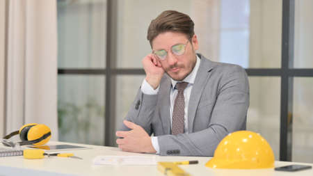 Sleepy Middle Aged Engineer Taking Nap While Sitting in Officeの写真素材