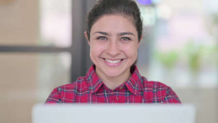 Close Up of Indian Woman with Laptop Smiling in Cameraの写真素材