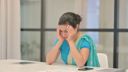 Upset Indian Woman Feeling Worried While Sitting in Officeの写真素材