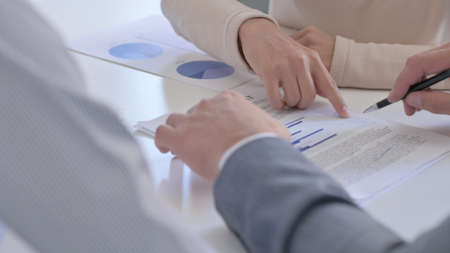 Close up of Hands of Business People Reading Documents, Writing on Paper