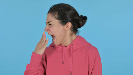 Sleepy Indian Girl Yawning, Blue Backgroundの写真素材