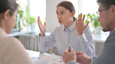 Latin Businesswoman with Reports Scolding Male and Female Colleaguesの写真素材
