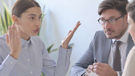 Angry Latin Businesswoman Arguing with Colleaguesの写真素材