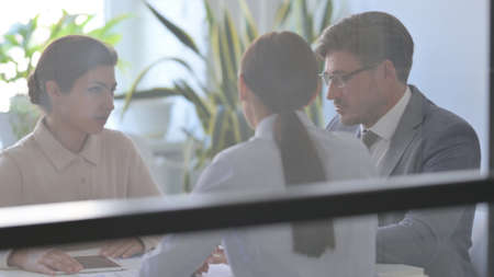Serious Businessman Talking Businesswoman in Modern Officeの写真素材