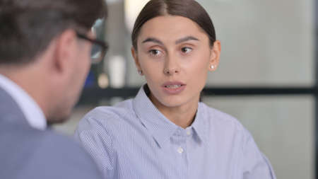 Serious Businesswoman Talking to Middle Aged Businessmanの写真素材