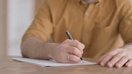 Hands Close up of Young Man Writing on Paper