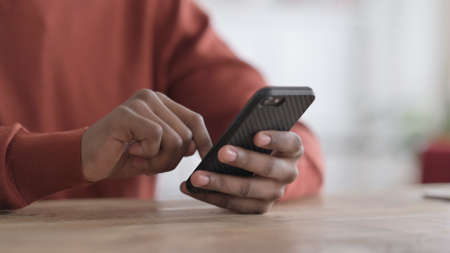 Hands Close up of African Man using Smartphone