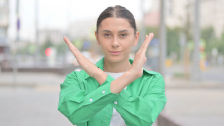Rejecting Hispanic Woman with Disliking Gesture Outdoor