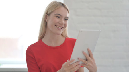 Portrait of Video Call on Tablet by Young Blonde Woman in Office