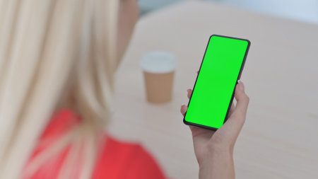 Young Blonde Woman Using Smartphone with Green Screenの写真素材
