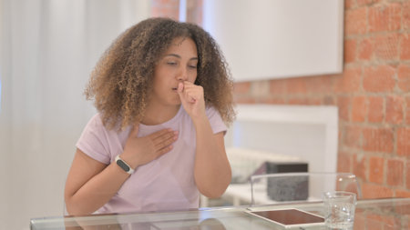 African American Woman Coughing While Sitting at Home