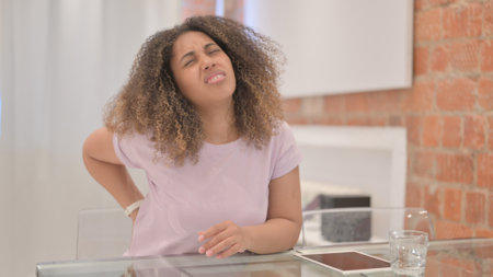 African American Woman with Back Pain Sitting at Home